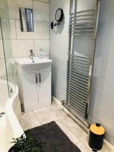 a bathroom with a toilet and a sink and a shower at Spacious 3 bed house near beach! in Lowestoft