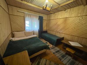 a small room with a bed and a window at ЛІСОВА ХАТИНКА in Kelechin