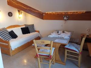 - une chambre avec un lit, une table et des chaises dans l'établissement Appartement cosy dans chalet vue Montagne, à Saint-Étienne-en-Dévoluy