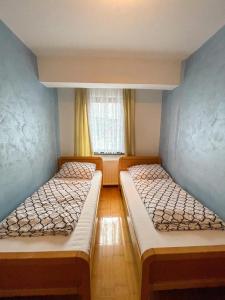 two beds in a small room with a window at Apartment Love in Vlasic