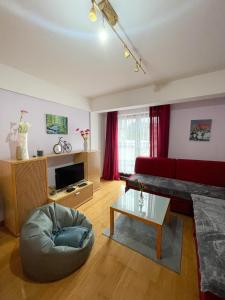 ein Wohnzimmer mit einem roten Sofa und einem Tisch in der Unterkunft Apartment Love in Vlasic