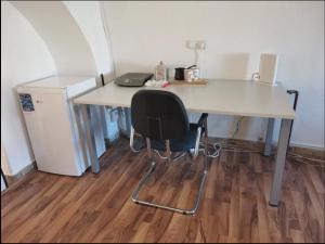białe biurko z krzesłem i lodówka w obiekcie Unique studios near Tivoli w Lublanie