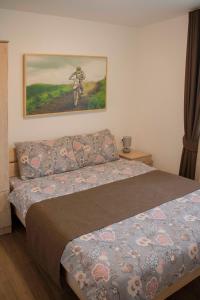 ein Schlafzimmer mit einem Bett und einem Wandgemälde in der Unterkunft Rajački Konaci in Polom
