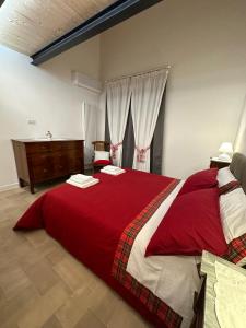 a bedroom with a large bed with red blanket at Appartamento ad Orvieto in Orvieto