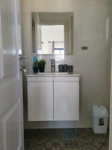 a white bathroom with a sink and a window at נופש מול הכנרת Vacation in front of the Sea Galilee in Tiberias