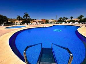 une grande piscine d'eau bleue dans l'établissement Villas Rurales Arroyovil, à Mancha Real