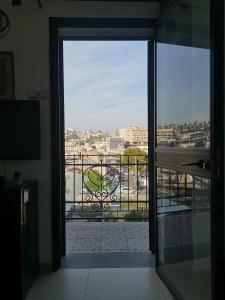 an open door to a balcony with a view of a city at נופש מול הכנרת Vacation in front of the Sea Galilee in Tiberias