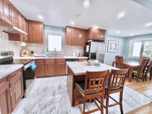 - une cuisine avec des placards en bois, une table et des chaises dans l'établissement Newly Renovated Detached Home Near Finch Subway Station, à Toronto