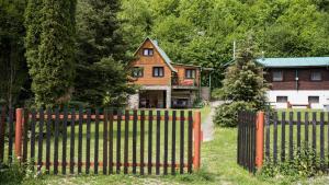 una recinzione di legno di fronte a una casa di Chata Jánošík a Terchová