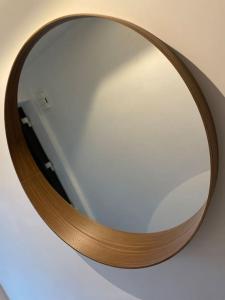 un miroir avec un cadre en bois sur un mur dans l'établissement Appartement à Courrière, à Assesse