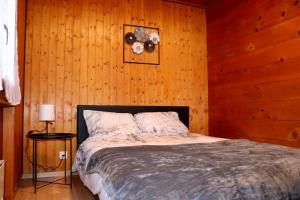 een slaapkamer met een bed in een houten muur bij L'appel Chalet in Choex