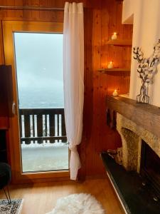 een woonkamer met een open haard en uitzicht op de oceaan bij L'appel Chalet in Choex