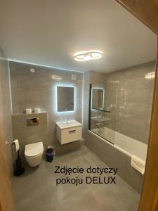 a bathroom with a toilet and a sink and a tub at Leśna Polana in Sękocin Stary