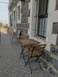zwei Holztische und Bänke neben einem Gebäude in der Unterkunft נופש מול הכנרת Vacation in front of the Sea Galilee in Tiberias