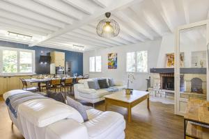 a living room with white furniture and a fireplace at Villa de la Côte - Welkeys in Labenne