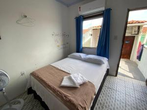 a small bedroom with a bed and a window at Guarnicê Hostel in São Luís