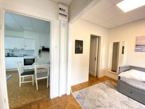 a bedroom with a bed and a table and a kitchen at central apartment with free parking in Huskvarna
