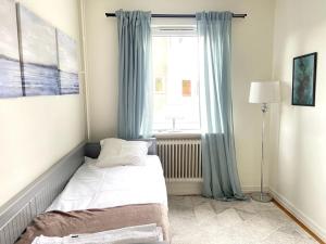 a small bedroom with a bed and a window at central apartment with free parking in Huskvarna