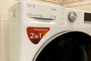 uma máquina de lavar roupa branca com um cartaz em central apartment with free parking em Huskvarna