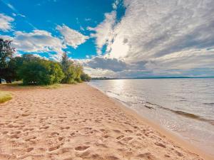 a beach with footprints in the sand and the water at central apartment with free parking in Huskvarna