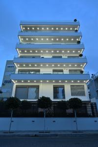 ein hohes weißes Gebäude mit Lichtern drauf in der Unterkunft The Lop Athens Holidays Luxury Suites in Athen