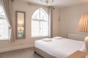 a white bedroom with a bed and a mirror at Charming 2 Bed House in Tewkesbury Centre in Tewkesbury