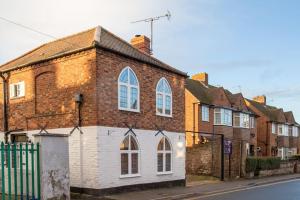 an old brick building on a city street at Charming 2 Bed House in Tewkesbury Centre in Tewkesbury