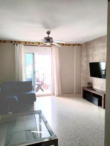 sala de estar con ventilador de techo y TV en CHIPIONA SOL Y PLAYA, en Chipiona
