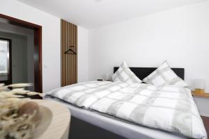 Un dormitorio con una gran cama blanca y una mesa en Ferienwohnung mit exklusiver Aussicht im Wander- und Bikeparadies Schwarzwald en Donaueschingen