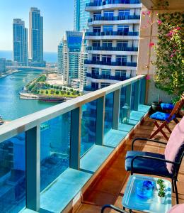 Fabolous Vacation Home in Dubai Marina في دبي: شرفة مع كراسي وإطلالة على الماء