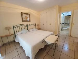 a bedroom with a white bed and a chair at Apto. PIÑA DE MAR in Adeje