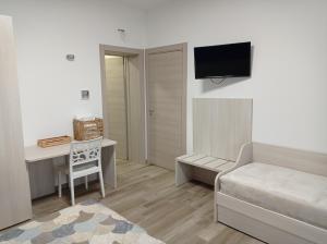 Schlafzimmer mit einem Bett, einem Schreibtisch und einem TV in der Unterkunft Dimora Pianelle in Crispiano