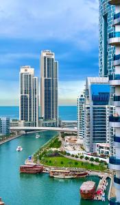 eine Stadt mit hohen Gebäuden und einem Fluss mit Booten in der Unterkunft Fabolous Vacation Home in Dubai Marina in Dubai