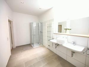 a white bathroom with two sinks and a shower at Zollikof Aparts - Sauna & Studioapartments in Leipzig +56 photos