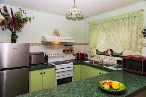 a kitchen with a refrigerator and a bowl of fruit on a counter at Ballarat Aroma Cottage in Ballarat