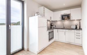 eine Küche mit weißen Geräten und einem großen Fenster in der Unterkunft Garden Suite in Binz