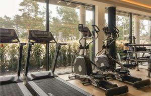einen Fitnessraum mit mehreren Kardiogeräten und einem Fenster in der Unterkunft Garden Suite in Binz