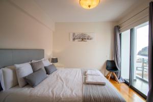 a bedroom with a large bed with a large window at Casa da Graça by AnaLodges in Machico