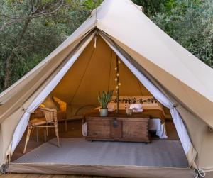 Zelt mit einem Bett und einem Tisch in der Unterkunft Rälla Camp - Öland in Borgholm