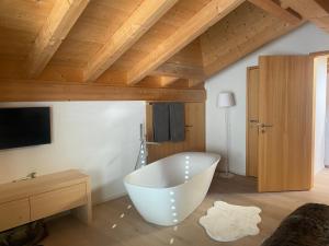 un bagno con una grande vasca bianca in una stanza di Klosters/Davos - topfloor luxury apartment with extraordinary views a Klosters Dorf