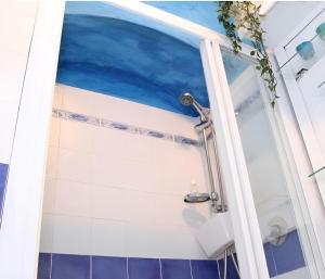 y baño con ducha y azulejos azules y blancos. en Giulia Appartamento, 250mt da Ponte Vecchio, en Florencia