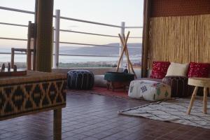 a living room with a couch and a large window at Caban Surf Tamraght in Tamraght Ouzdar