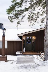 een huis met een groene deur in de sneeuw bij Rangeley Lake House, lake access, Saddleback 15min in Rangeley