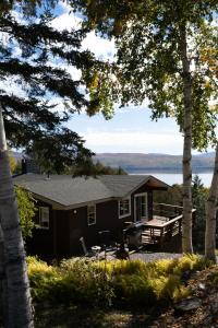 a cabin with a view of a lake through the trees at Rangeley Lake House, lake access, Saddleback 15min in Rangeley