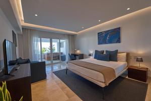 - une chambre avec un lit et une télévision à écran plat dans l'établissement Punta Palmera ocean views 1bed apartment Cap Cana, à Punta Cana