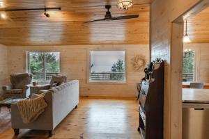 sala de estar con paredes de madera y techo en Rangeley Lake House, lake access, Saddleback 15min, en Rangeley