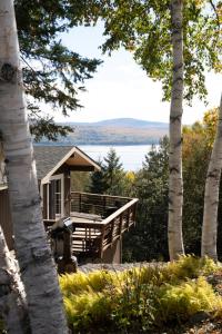 een huis met een terras met uitzicht op een meer bij Rangeley Lake House, lake access, Saddleback 15min in Rangeley