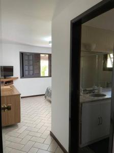 a kitchen with white walls and a open doorway at Casa Barlavento com Piscina e Praia em Angra - RJ in Angra dos Reis