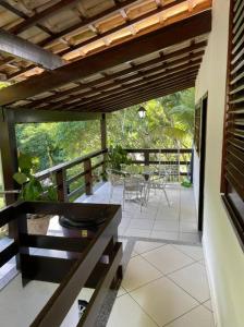 a balcony of a house with a table and chairs at Casa Barlavento com Piscina e Praia em Angra - RJ in Angra dos Reis
