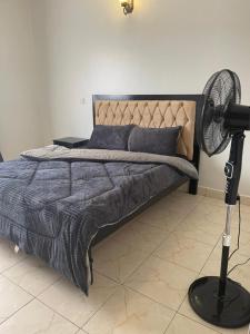 1 dormitorio con 1 cama y ventilador al lado en lii homes, en Kampala
